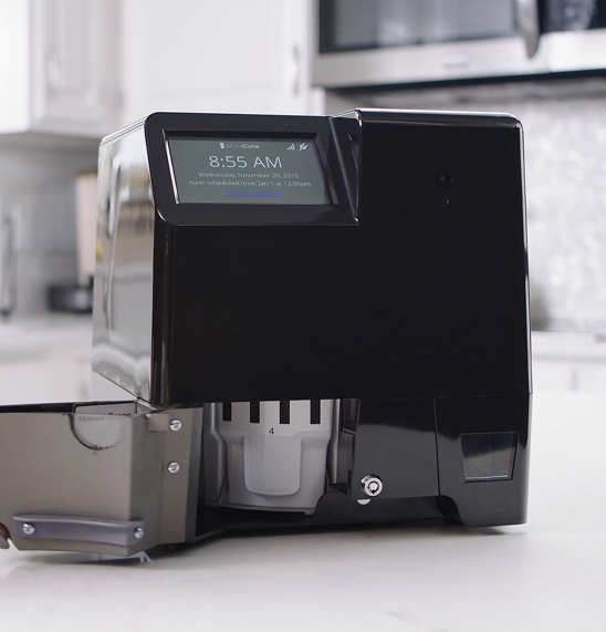 MedaCube device sitting on a counter in a kitchen with the restock bin open a large bin number 4 is visible.