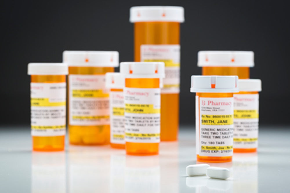 Various prescription pill bottles and teo loose pills.